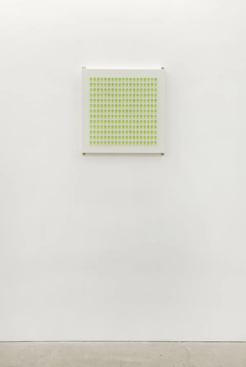 Lime-green fittings on a square panel shown against a white wall