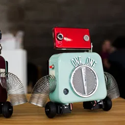 One One, a robot with a mint-green speaker body and red camera head