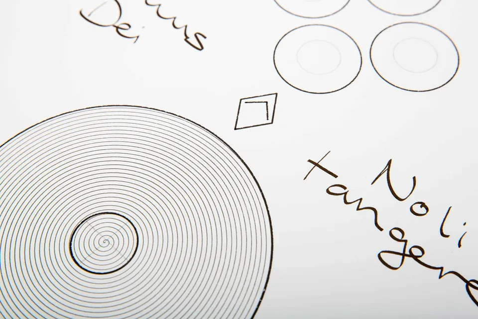 Close view of the spiral, diamond, circles, and handwritten Latin words in The Final Word.
